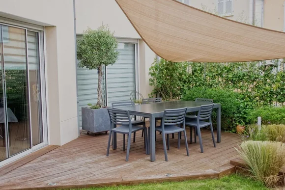 Holzterrasse mit Gartenmöbeln und Sonnensegel